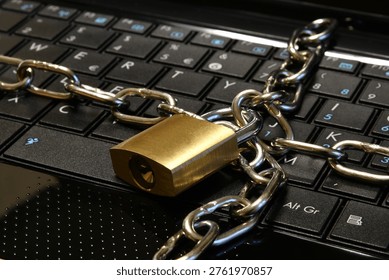 Computer security concept with an iron chain and padlock on the laptop keyboard