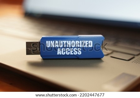 Computer and security concept. On the laptop keyboard is a flash drive with the inscription - Unauthorized Access