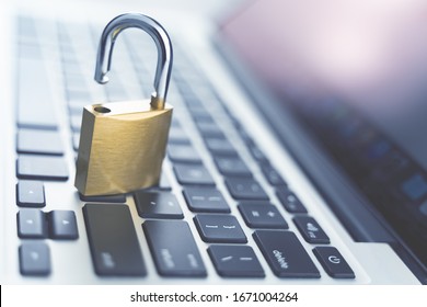 Computer security concept. Unlocked padlock on laptop keyboard. Symbol of safe. Toned soft focus picture.
