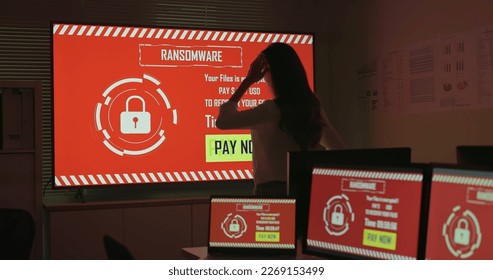 Computer security and extortion concept - asian worried young businesswoman holding digital tablet is looking at screen with ransomware attack words in office