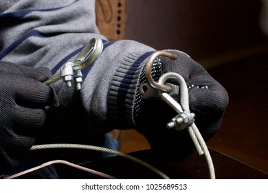 Computer security. Protection of access to data. The tablet is protected by a security cable and a lock. An attacker with gloves tries to open the lock and get access to the computer.