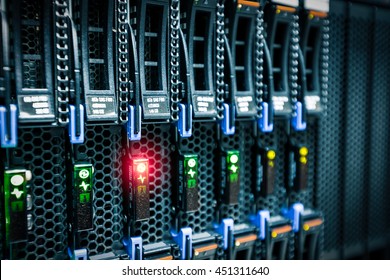 Computer Server mount on rack in data center room with red lighting alarm.
