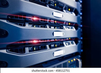 Computer Server mount on rack in data center room with red lighting alarm.
