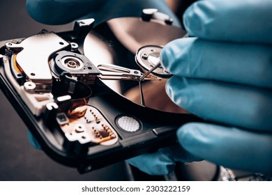 Computer service engineer technician workplace repairing fixing disassembled HDD hard drive data disc SSD, backup part of PC or laptop. Recovery, maintenance work, access file. Profession repairman

 - Shutterstock ID 2303222159