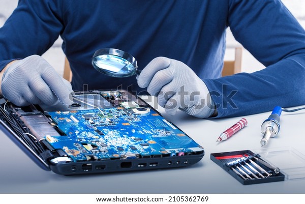 Computer service and repair concept. Man\
repairing the broken computer in\
office.