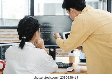 IT computer software developer team, programmer, software engineer and software analysis working on computer sourcecode project. Team of developers cooperating while working on desktop PC.