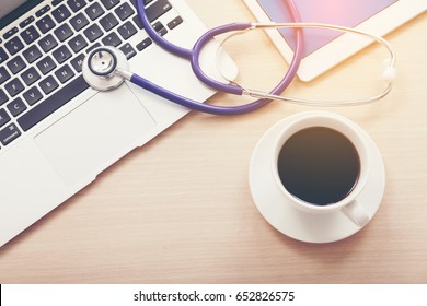 Computer, Stethoscope, Coffee Cup And Tablet Or Smart Phone On Desk Taking Coffee Break