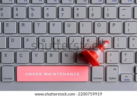 Computer system under construction, maintenance, repair concept. Safety cone and keyboard computer