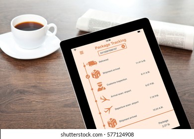 computer tablet with app tracking delivery package on table in office