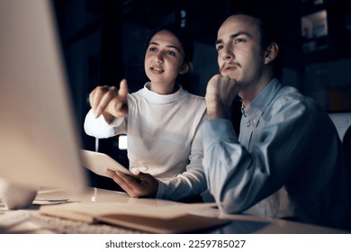 Computer, teamwork and people night office for information technology, programming and software development. Programmer, coding and cybersecurity analytics woman with partner on pc strategy in dark - Powered by Shutterstock