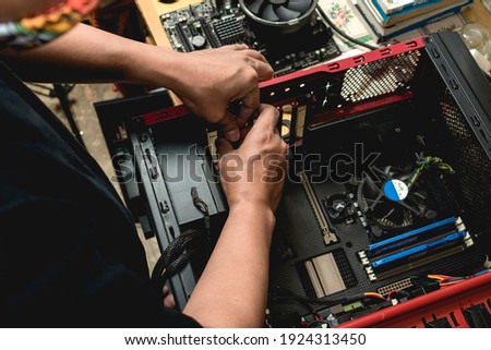 A computer technician assembles a desktop computer with new parts. Upgrading or replacing PC parts.