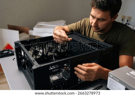Computer technician installing internal hardware components, precision-focused working inside desktop pc case, optimizing system performance and reliability. Concept of desktop PC maintenance