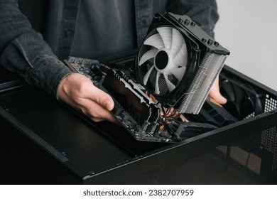 Computer technician installs cooling system of computer. Assembling PC	
