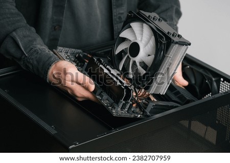 Computer technician installs cooling system of computer. Assembling PC	
