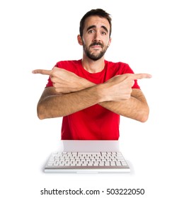 Computer technician working with his keyboard pointing to the laterals having doubts