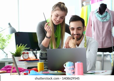 Computer Technology in Sewing Fashion Needlecraft. Smiling Man and Glad Woman Designers Creating Fashion Apparel Using Laptop. Beautiful People Working at Dressmaking Workshop Studio - Powered by Shutterstock