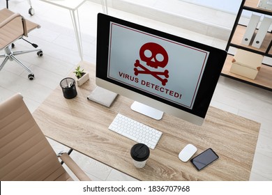 Computer with warning about virus attack on screen in office