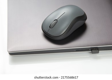 Computer wireless mouse next to a laptop on a white table close-up. electronic personal industry