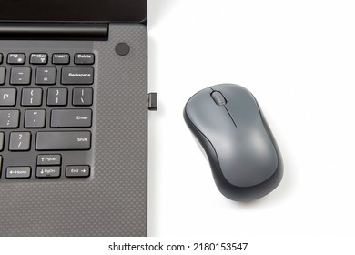 Computer wireless mouse next to a laptop on a white table close-up. electronic personal industry