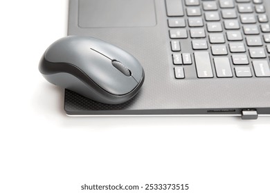 Computer wireless mouse next to a laptop on a white table close-up. electronic personal industry - Powered by Shutterstock