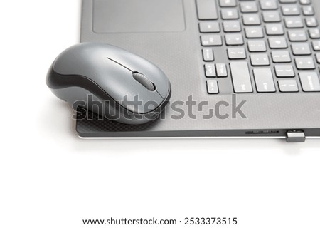 Computer wireless mouse next to a laptop on a white table close-up. electronic personal industry