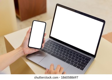 Computer,Handy Blankobildschirm mock up.hand Frau arbeiten mit Laptop-SMS-Handy. mit weißem Hintergrund für Werbung, Kontaktaufnahme mit Geschäftsinformationen auf dem Schreibtisch in cafe.marketing,Design
