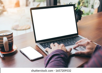 computer,cell phone mockup image blank screen with white background for advertising text,hand man using laptop texting mobile contact business search information on desk in cafe.marketing,design