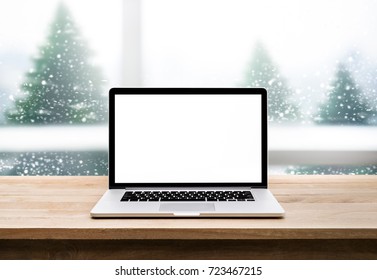 Computer,laptop with blank screen on window view and snowfall in outside.christmas winter backgrounds