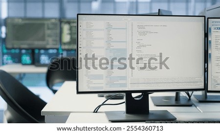 Computers in data center hosting rackmount ensuring faultless operations conditions. Close up of PC monitors on desk used for monitoring data center devices energy consumption, handheld camera shot