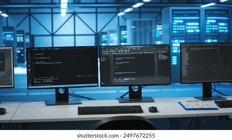 Computers in empty high tech data center establishment monitoring hardware energy consumption. PC monitors on desk used for checking potential system failures in server room