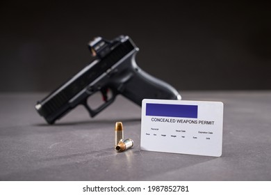 Concealed Weapons Permit With Semi-automatic Handgun With Red Dot Sight And Bullets On Table.           