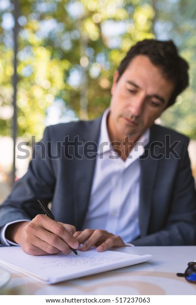 concentrate middle age businessman portrait writing stock photo concentrate middle age businessman portrait writing an essay outdoors in rome italy focus on