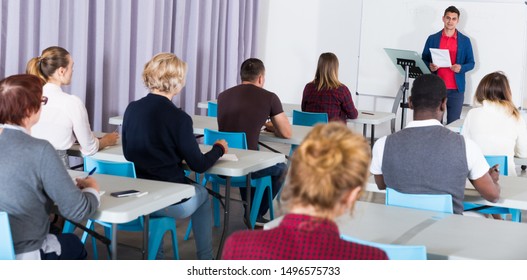 Concentrated Adult Students Of Different Nationalities With Teacher Studying In Classroom