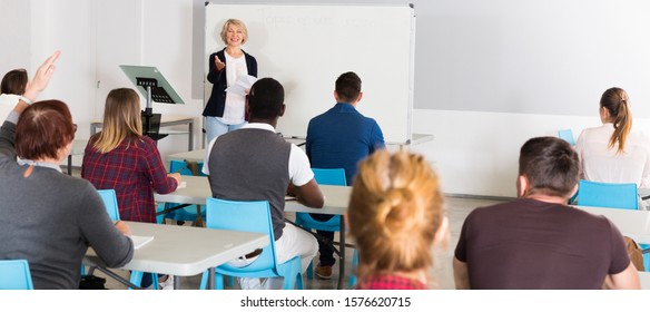 Concentrated Adult Students Of Different Nationalities With Teacher Studying In Classroom