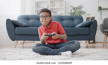 Concentrated African American Boy Having Fun Playing Video Game, Controlling Characters With Joystick