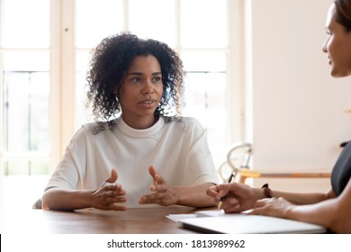 Concentrated African American female job applicant talk at job interview in office, focused confident biracial woman candidate speak negotiate with potential employer, hiring, recruitment concept - Powered by Shutterstock