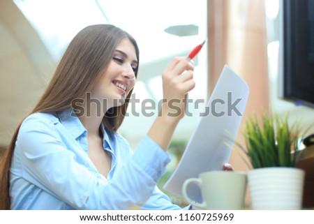 Concentrated business lady comparing documents at office.