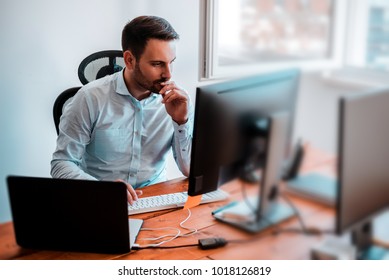 Concentrated Businessman Analyzing Graphs In His Office At Computer.