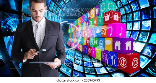 Concentrated businessman using magnifying glass against composite image of app wall
