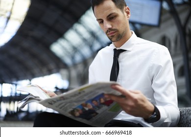 Concentrated Businessman In White Formal Shirt Analyzing Information From Morning Press While Waiting For Public Transport Getting To Job, Confident Entrepreneur Reading Newspaper On Train Station