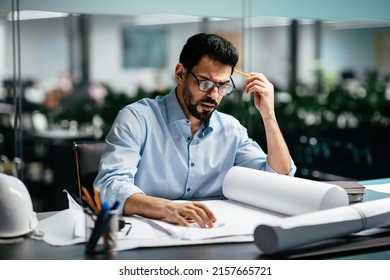 Concentrated Busy Smart Attractive Young Arab Man Engineer With Beard In Shirt, Glasses Thinking About Project In Office Interior. Professional Architect Working In Factory, Construction And Planning