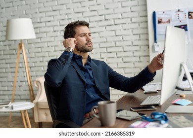 Concentrated caucasian businessman or ceo manager watching on computer at desk in office. High-tech business strategy, development, promotion, selling and marketing. Modern successful male lifestyle