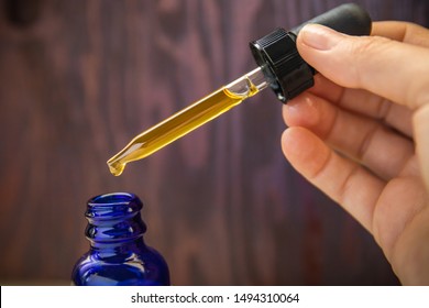 Concentrated CBD (cannabinoid) cannabis extract oil against wood background
