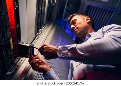Concentrated engineer adding new HDD to server