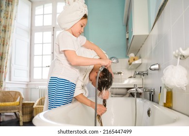 Concentrated Female Child Pouring Water Into Her Mother Head While Washing Head