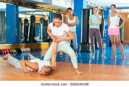 Concentrated hispanic female practicing effective self defence techniques with coach in training room - Powered by Shutterstock