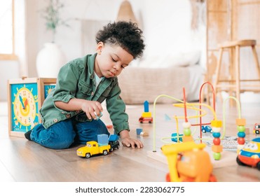 Concentrated little african american boy playing toys sitting on warm floor in modern living room. Baby development. Small tower. Learning creative concept - Powered by Shutterstock