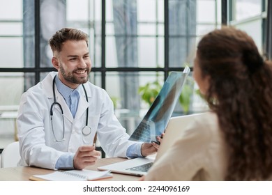 Concentrated male doctor looking at x-ray picture of spine - Powered by Shutterstock