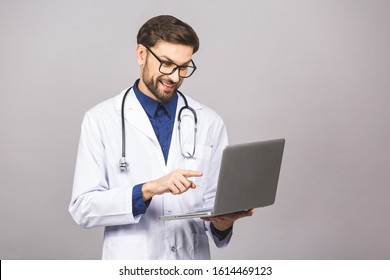 Concentrated Male Doctor Using Laptop Isolated Over Grey Background.