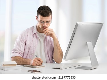 Concentrated Male Small Business Owner Looking At The Computer Screen While Sitting In Modern Office.